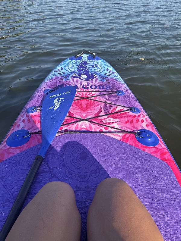 Stand up paddle board and paddle on the water.